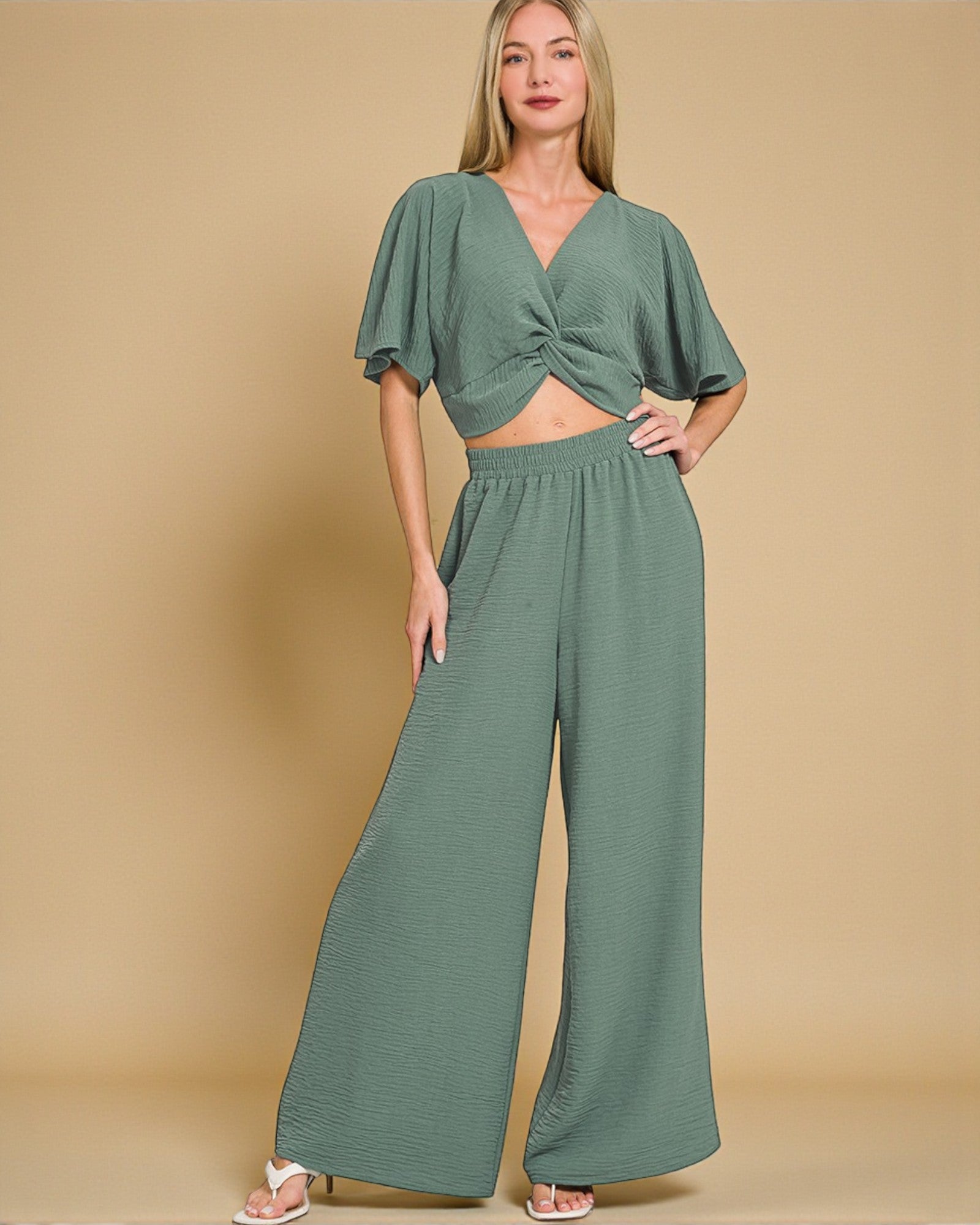 Woman wearing a green outfit with a beige background