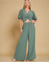 Woman wearing a green outfit with a beige background