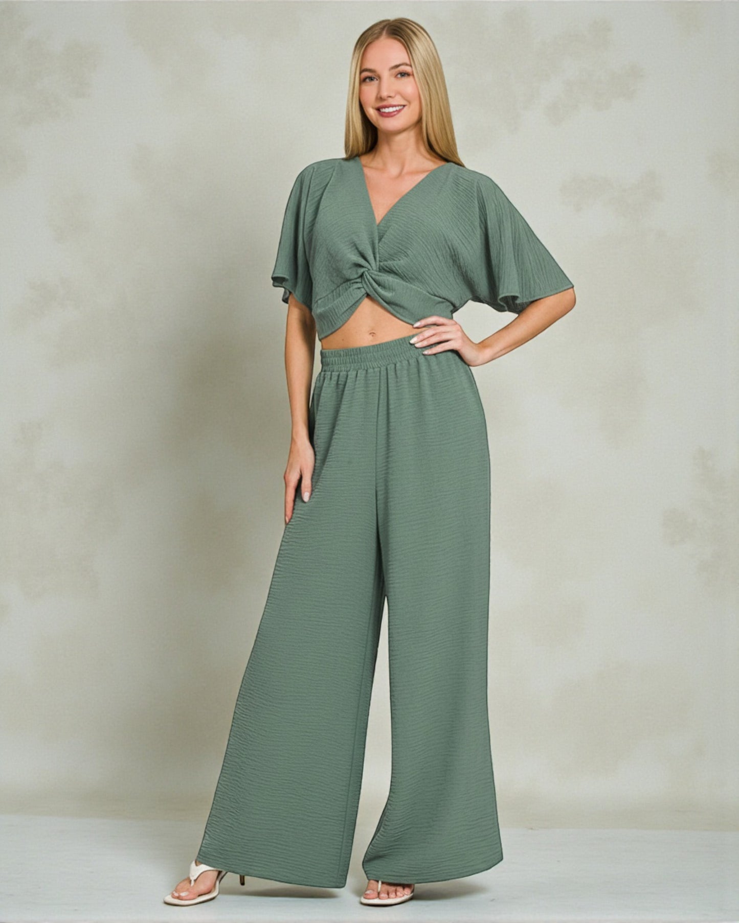 Woman wearing a green jumpsuit against a plain background