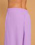 Purple pants worn by a person on a beige background