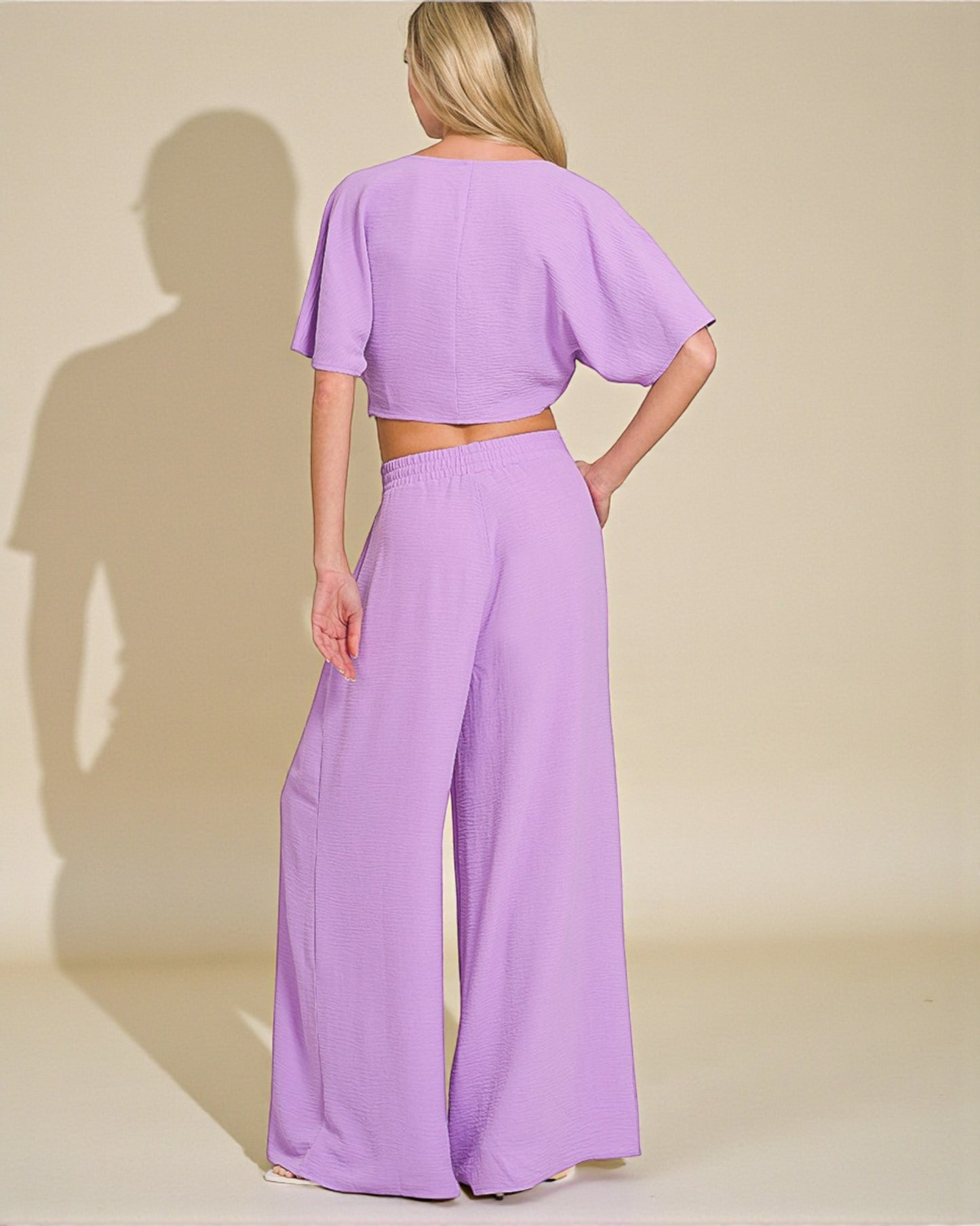 Woman wearing a lavender outfit with a plain background