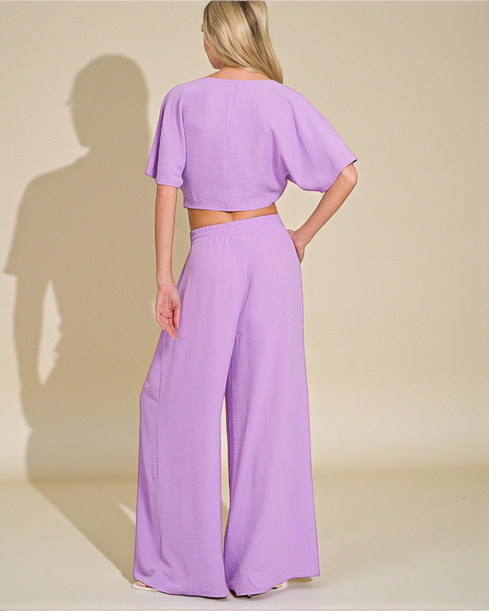 Woman wearing a lavender outfit with a plain background