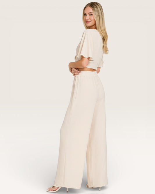 Woman wearing a cream-colored outfit on a white background