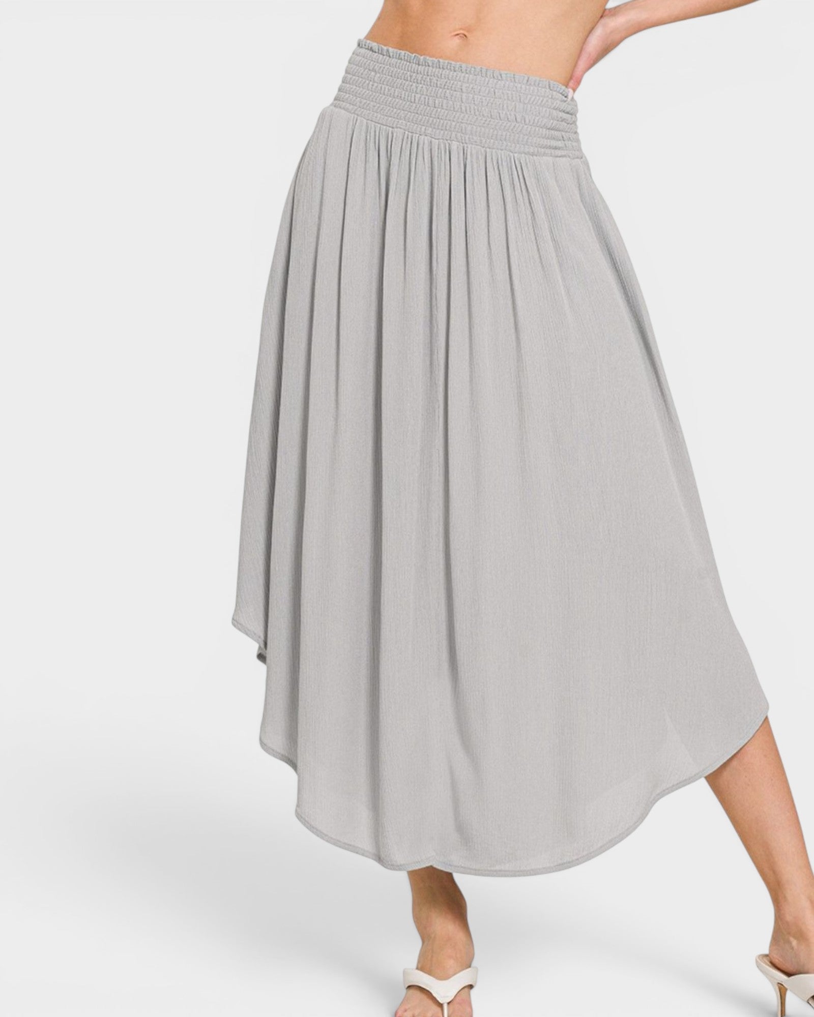 Gray pleated skirt worn by a person on a white background
