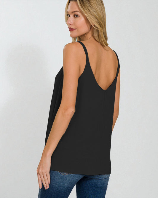 Woman wearing a black tank top and blue jeans on a white background