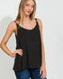 Woman wearing a black tank top and blue jeans on a white background