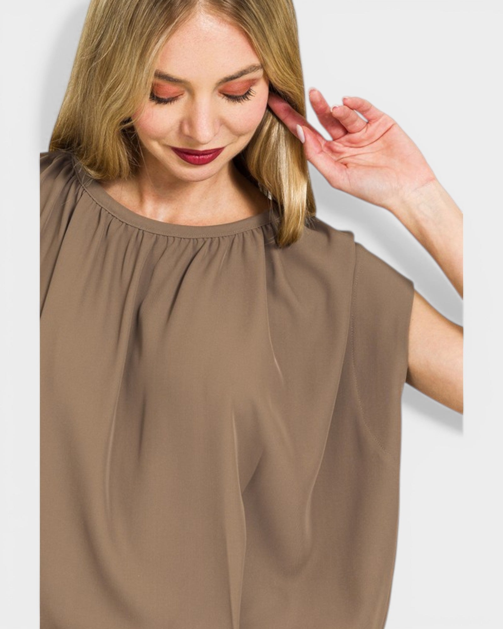 Woman wearing a brown blouse against a light background