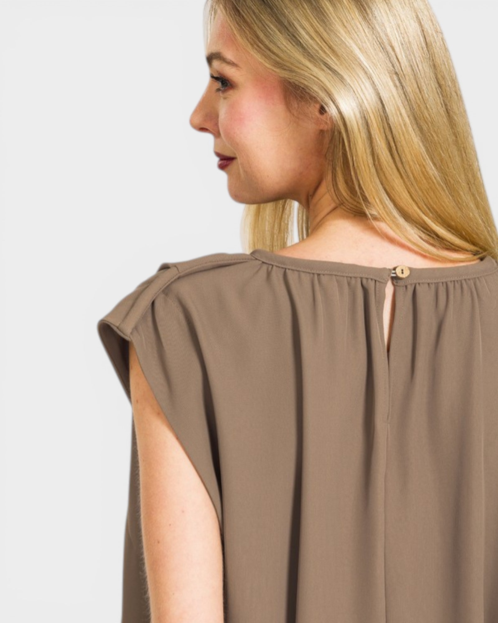 Woman wearing a brown sleeveless top against a white background