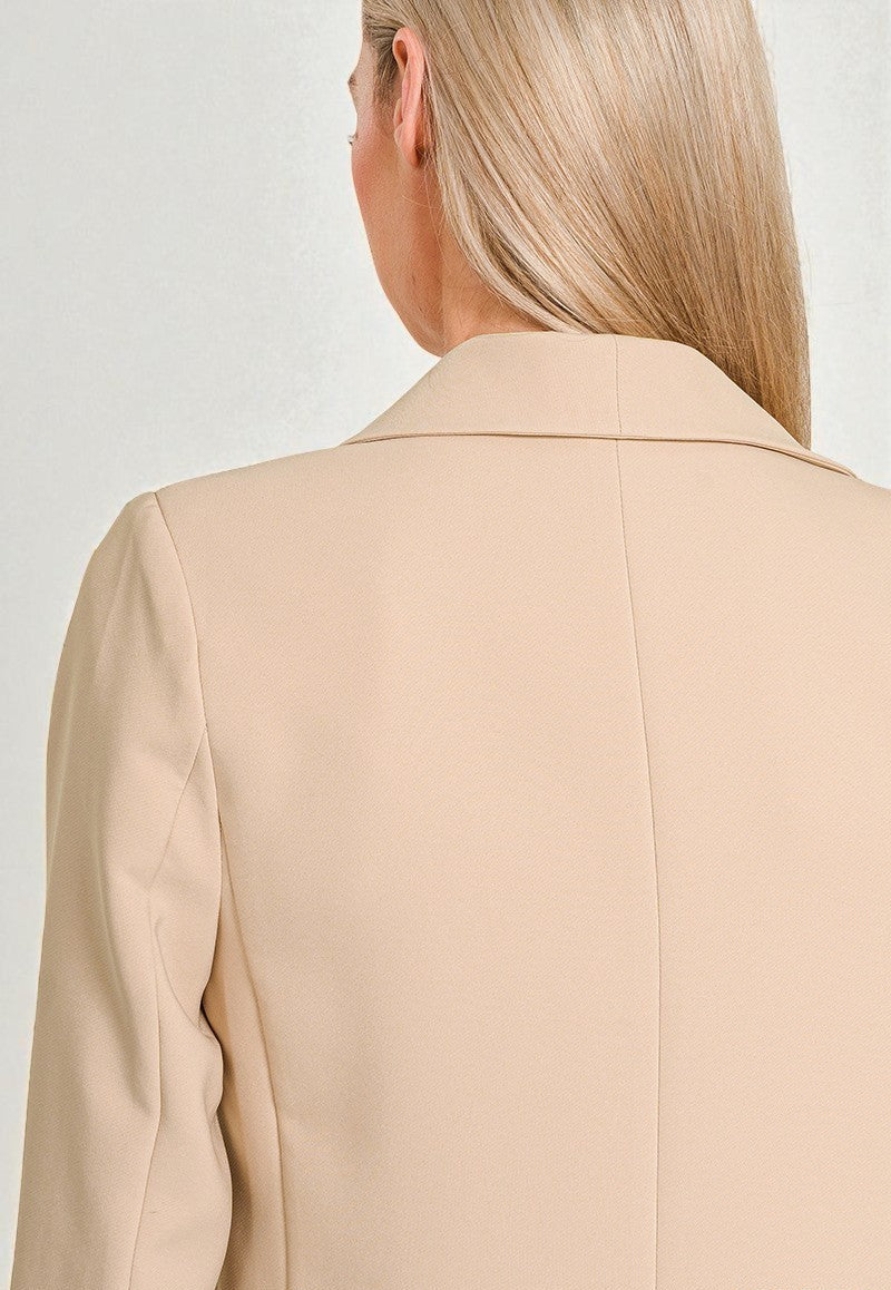 Light brown blazer worn by a person on a light gray background