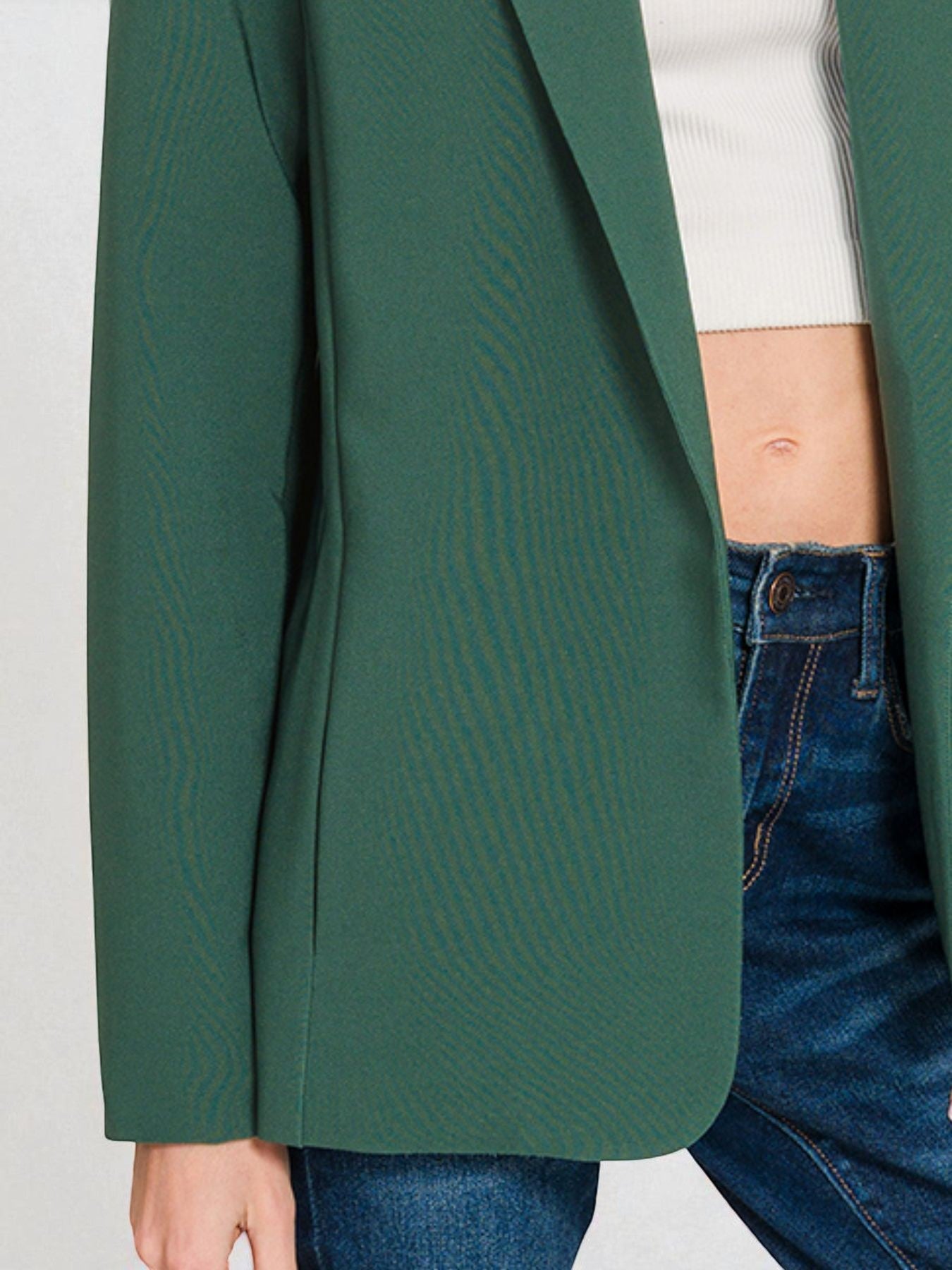 Green blazer worn by a person on a white background