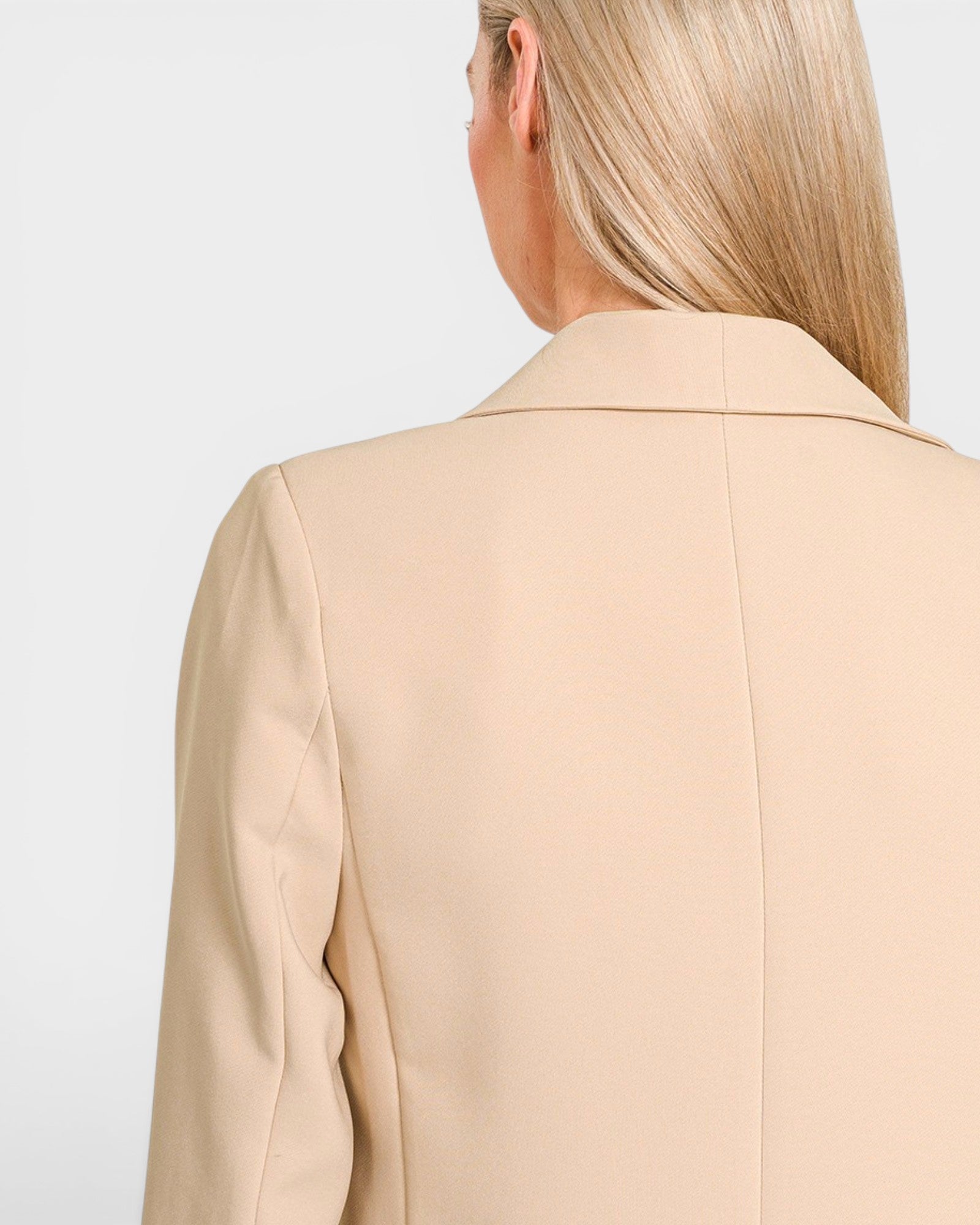 Beige blazer worn by a person on a light gray background