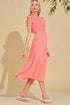 Woman wearing a coral dress against a beige background