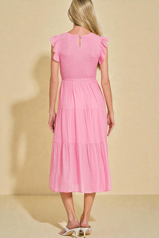 Woman wearing a pink dress against a beige background