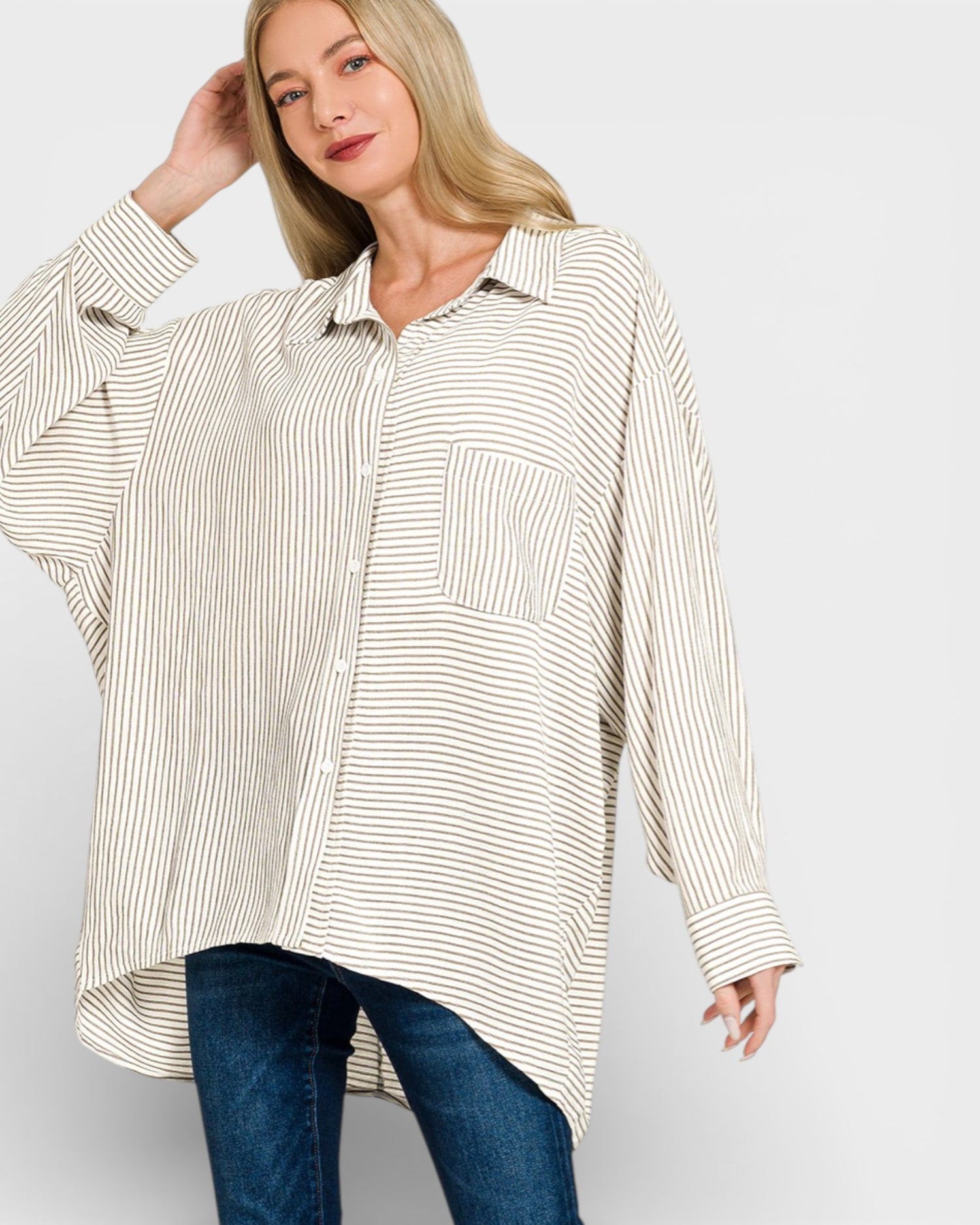 Woman wearing a striped shirt and jeans on a plain background