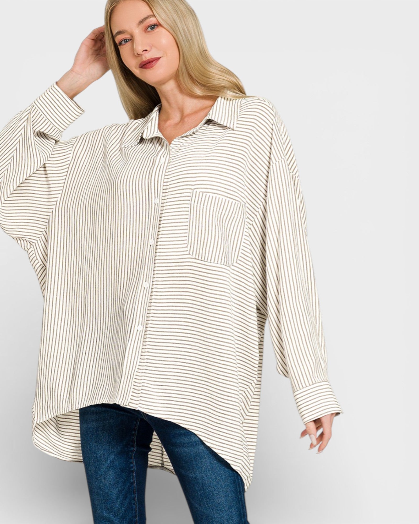 Woman wearing a striped shirt and jeans on a plain background