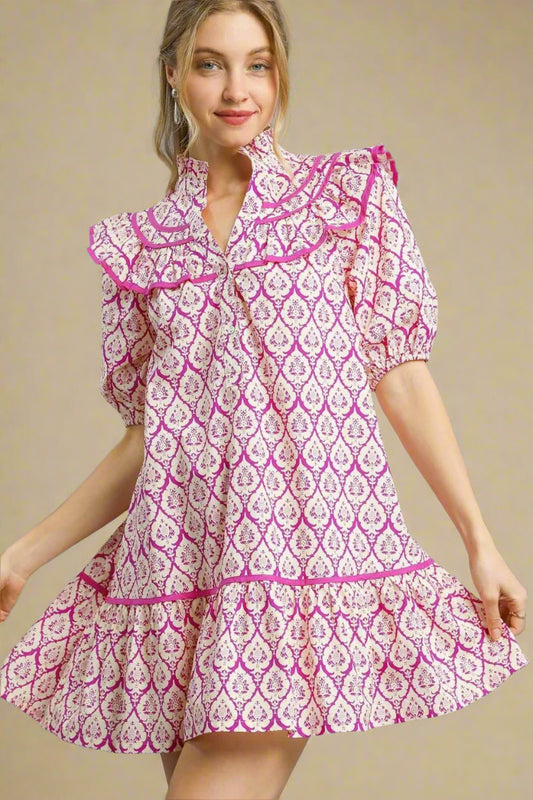 Woman wearing a pink and white patterned dress on a beige background