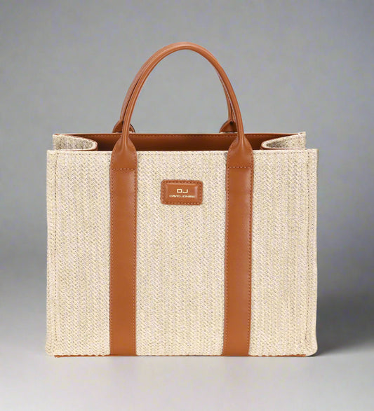 Beige straw tote bag with brown leather straps and handle on a white background