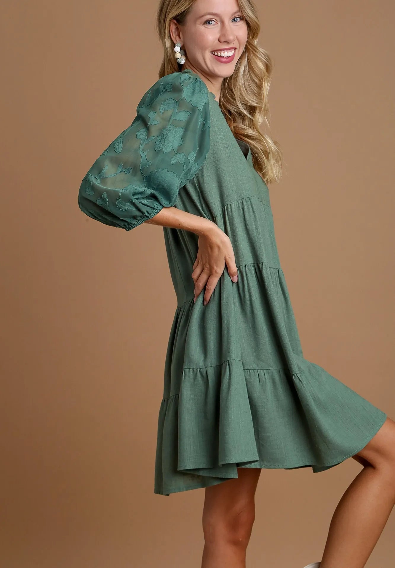 Woman wearing a green dress against a brown background