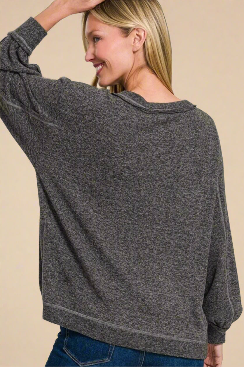 Woman wearing a gray sweater on a beige background