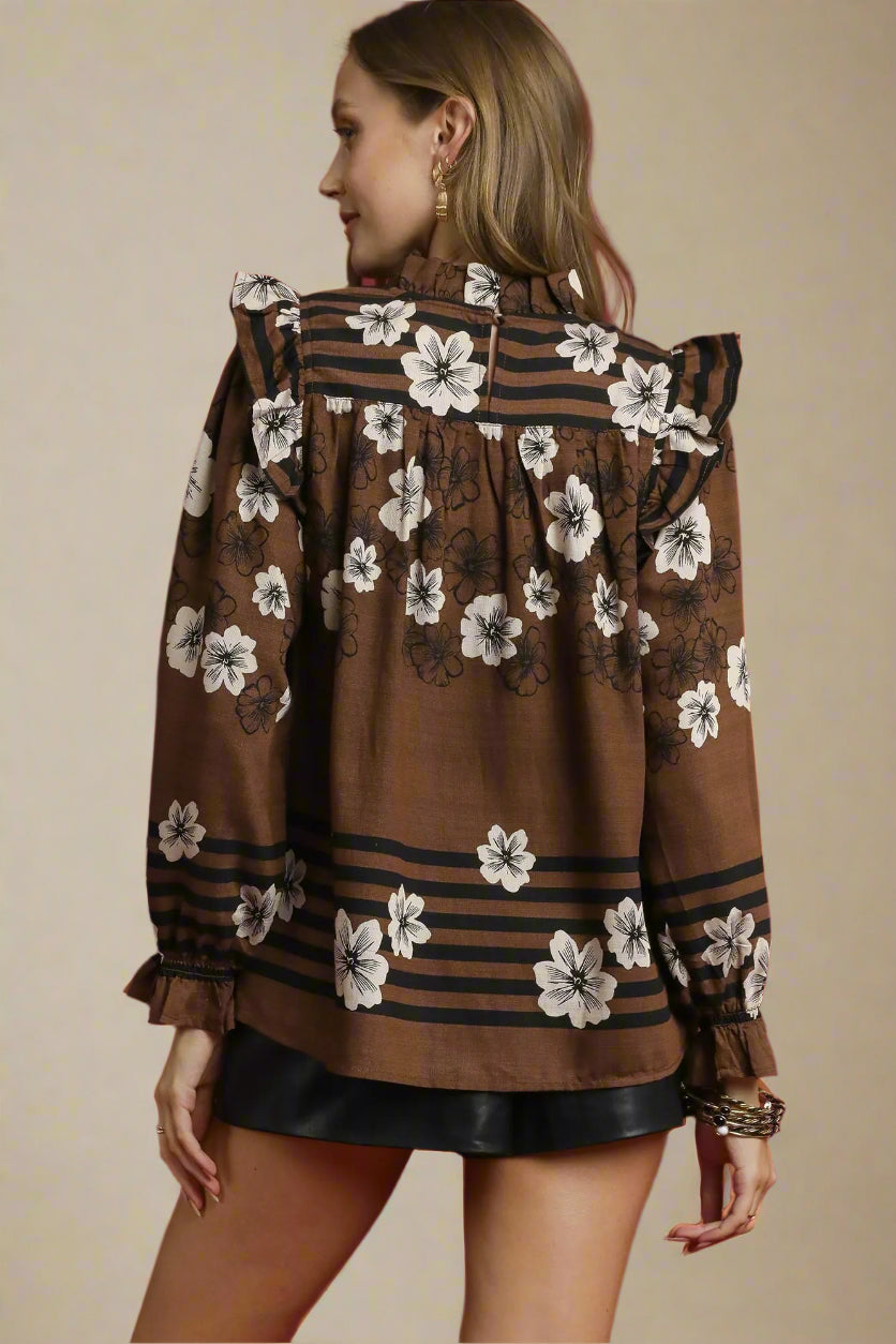 Woman wearing a brown floral blouse with a beige background