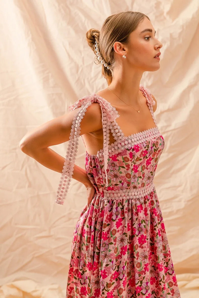 Woman wearing a floral dress with beaded straps against a beige background