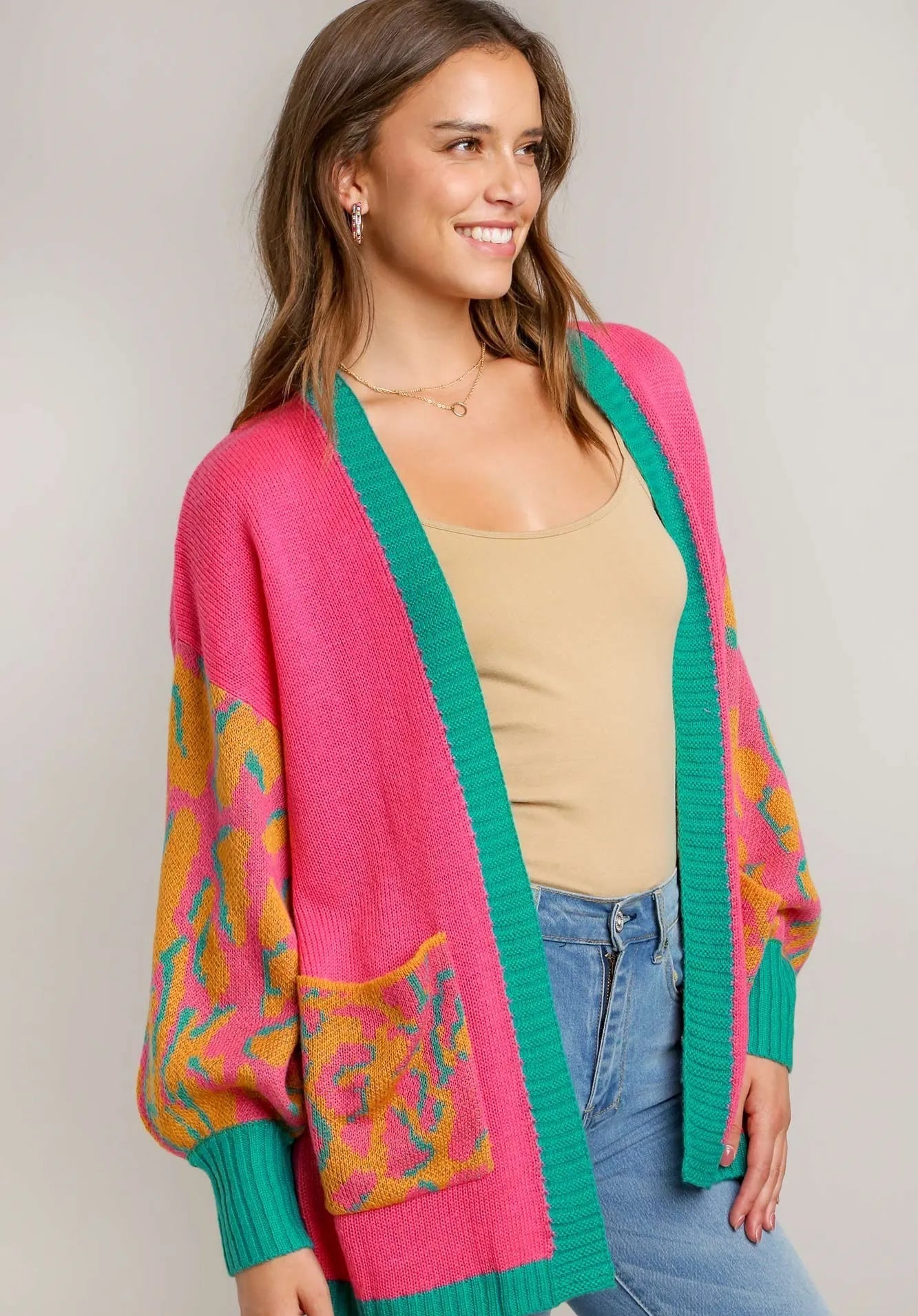 Woman wearing a colorful cardigan with a neutral background