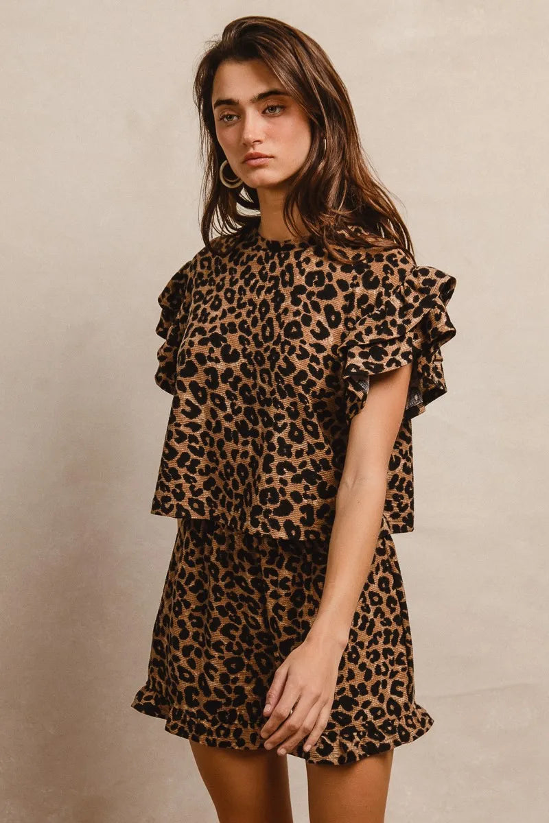 Woman wearing a leopard print outfit against a neutral background