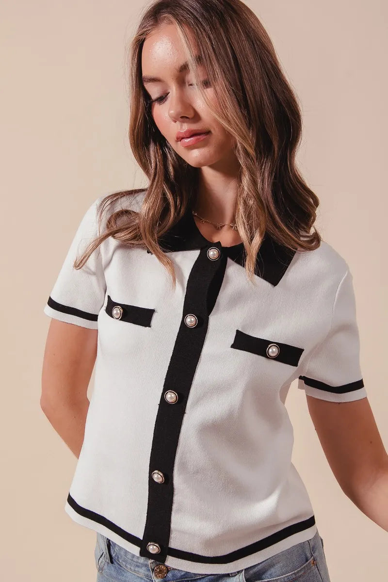 Woman wearing a white blouse with black accents on a beige background