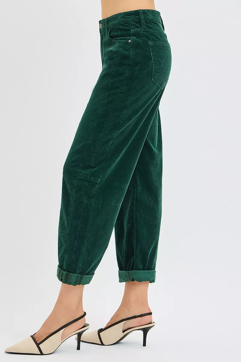 Green corduroy pants worn by a person on a white background