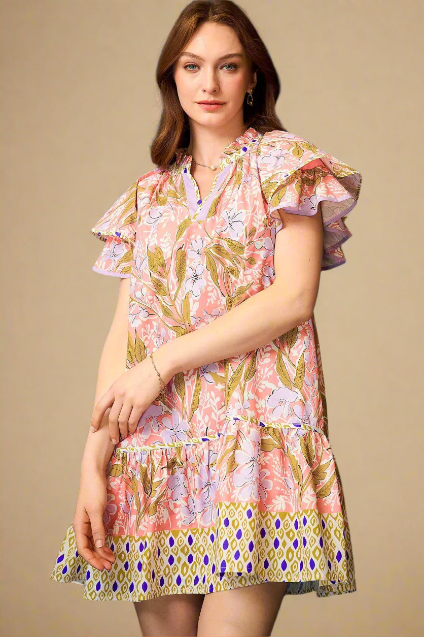 Woman wearing a colorful floral dress against a blue background