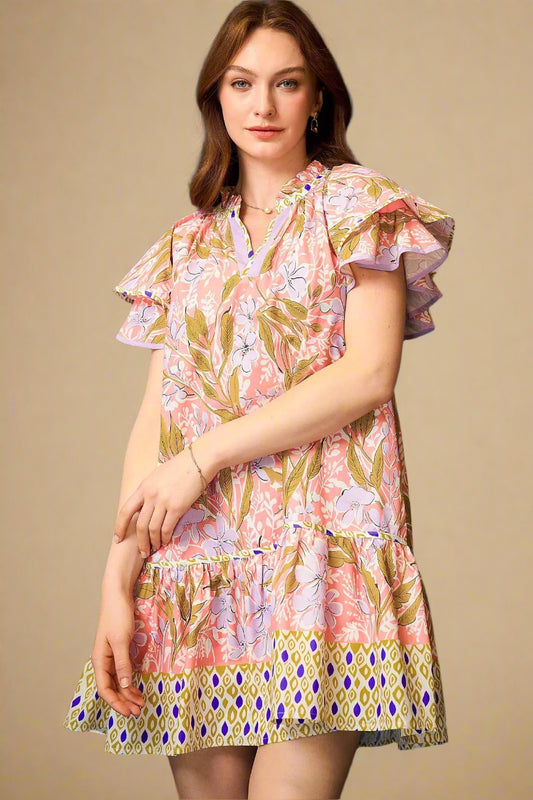 Woman wearing a colorful floral dress against a blue background