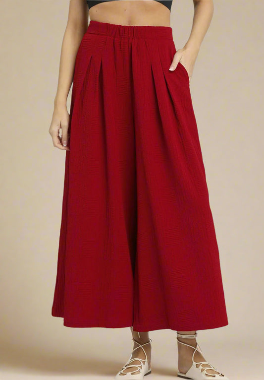 Red wide-leg pants worn by a person on a beige background