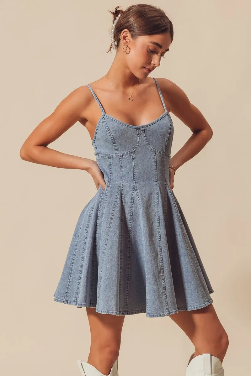 Woman wearing a denim dress against a beige background