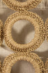 Close-up of woven circular patterns on a textured beige background