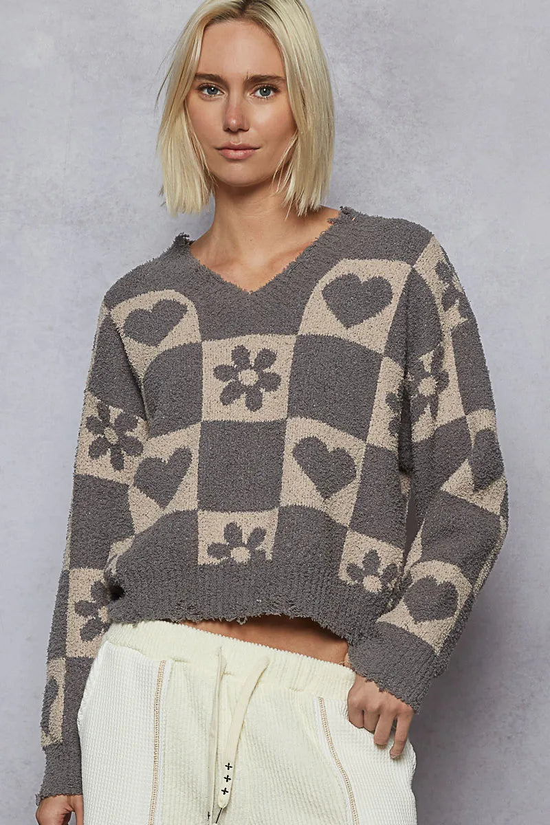 Woman wearing a patterned sweater against a plain background