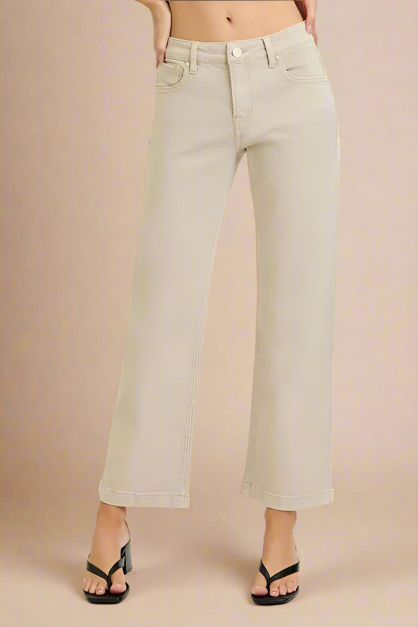 Beige wide-leg jeans worn by a person on a beige background