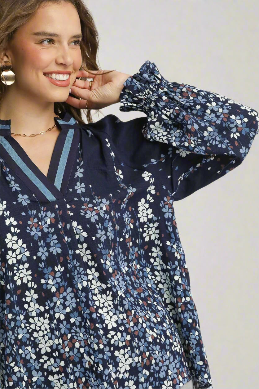Woman wearing a navy floral blouse with a white background