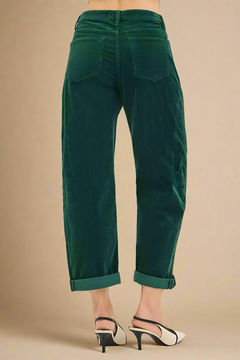 Green velvet pants worn by a person on a white background