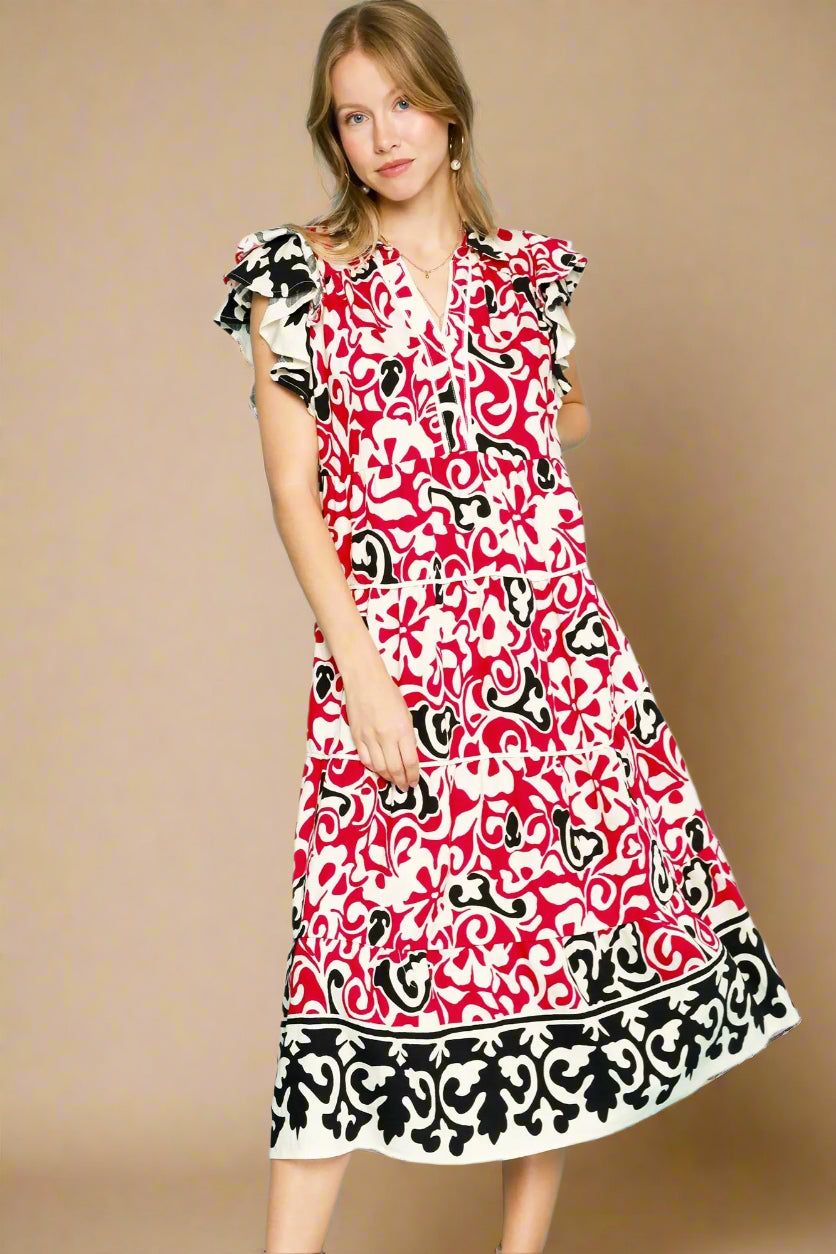 Woman wearing a red patterned dress against a beige background