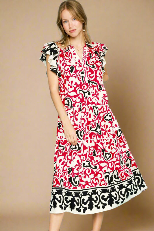 Woman wearing a red patterned dress against a beige background