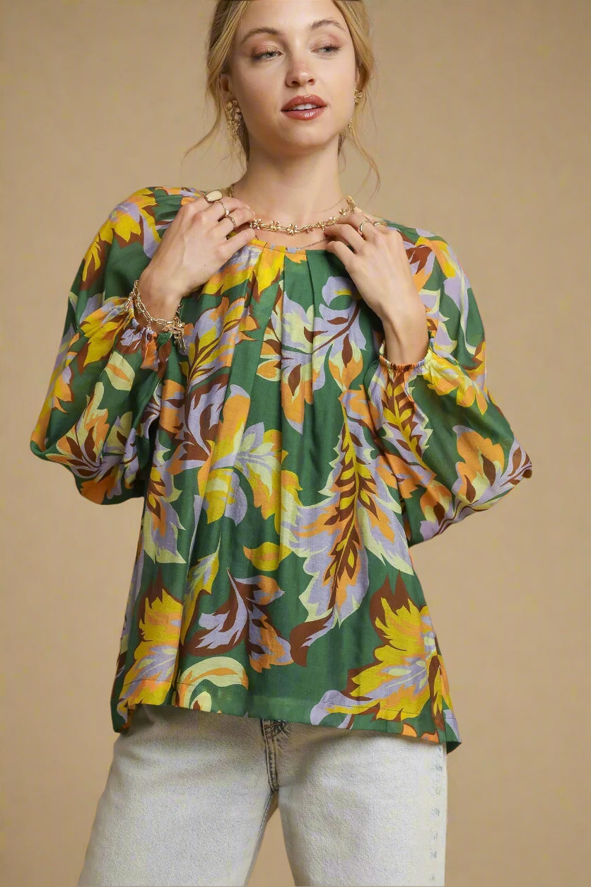 Woman wearing a colorful floral blouse against a beige background
