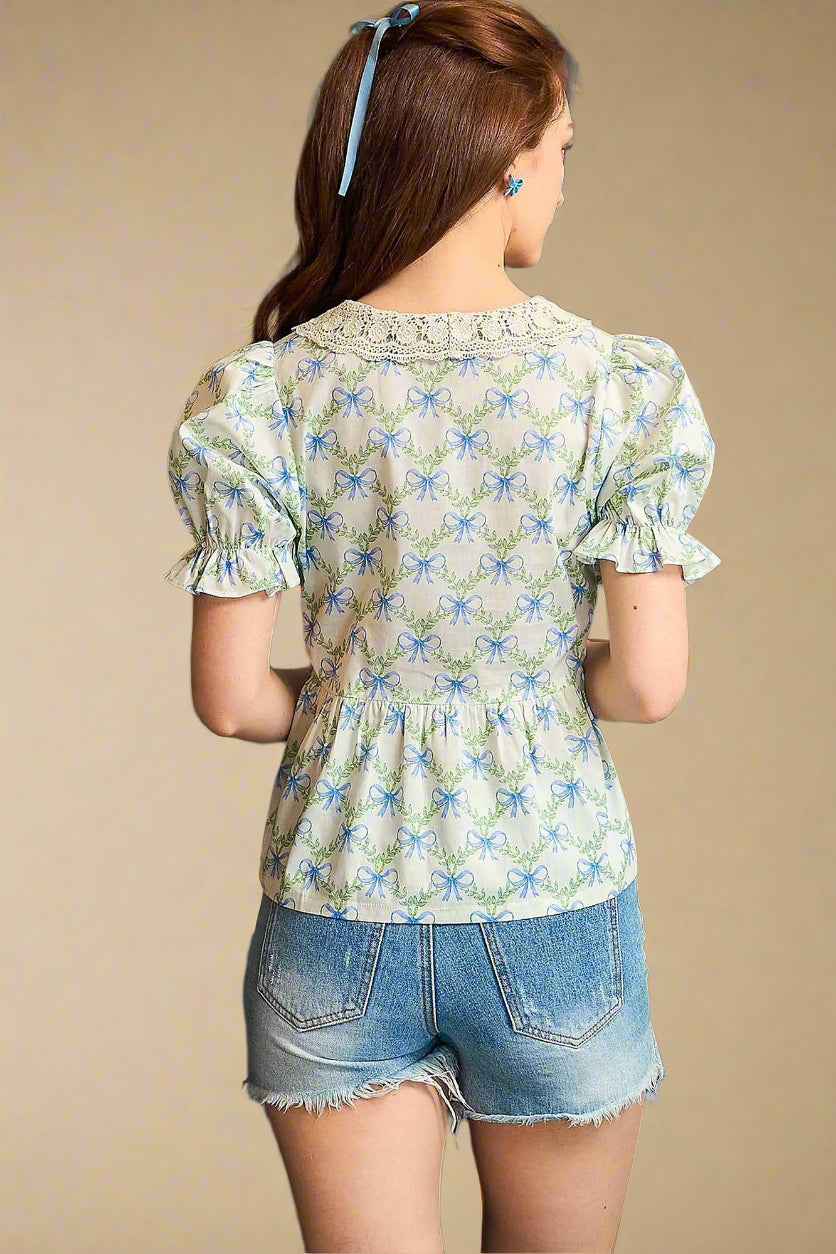 Woman wearing a floral blouse and denim shorts against a beige background