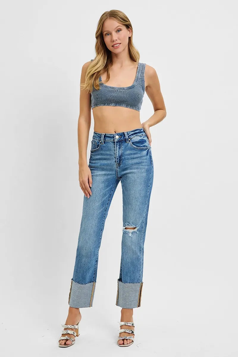 Woman wearing a blue crop top and jeans on a white background
