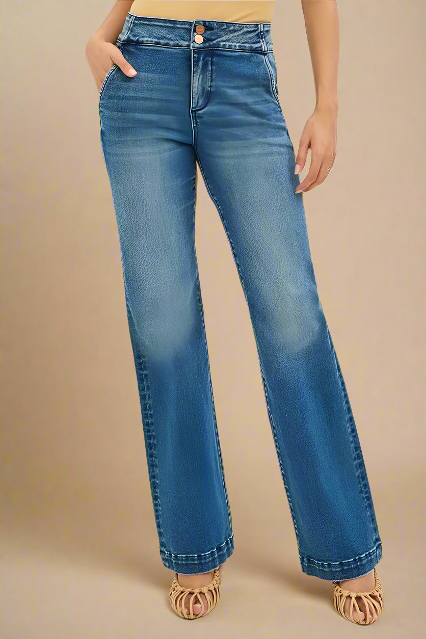 Blue jeans worn by a person on a beige background