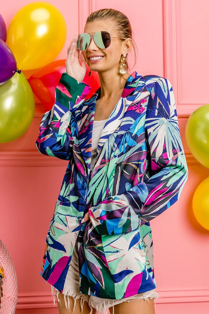 Woman wearing a colorful jacket with a pink background and balloons