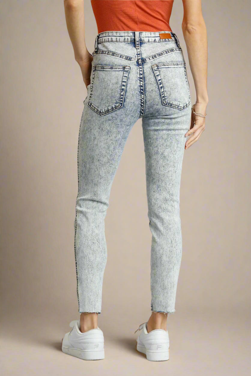 Light denim jeans worn by a person on a beige background