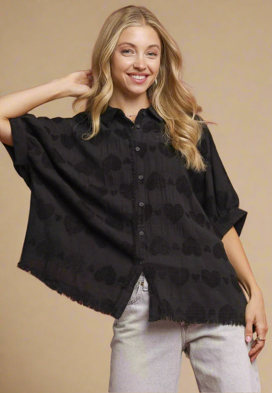 Woman wearing a black patterned shirt against a red background