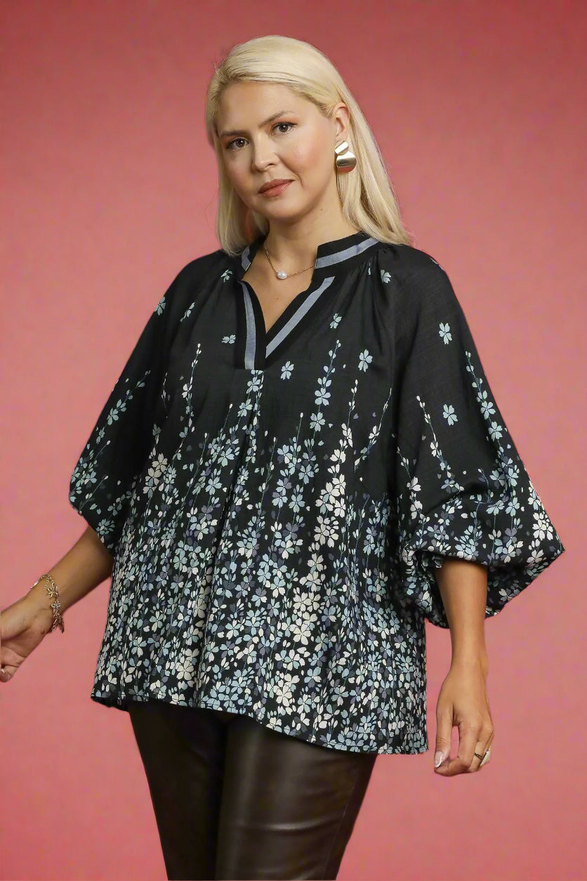 Woman wearing a black floral blouse against a red background