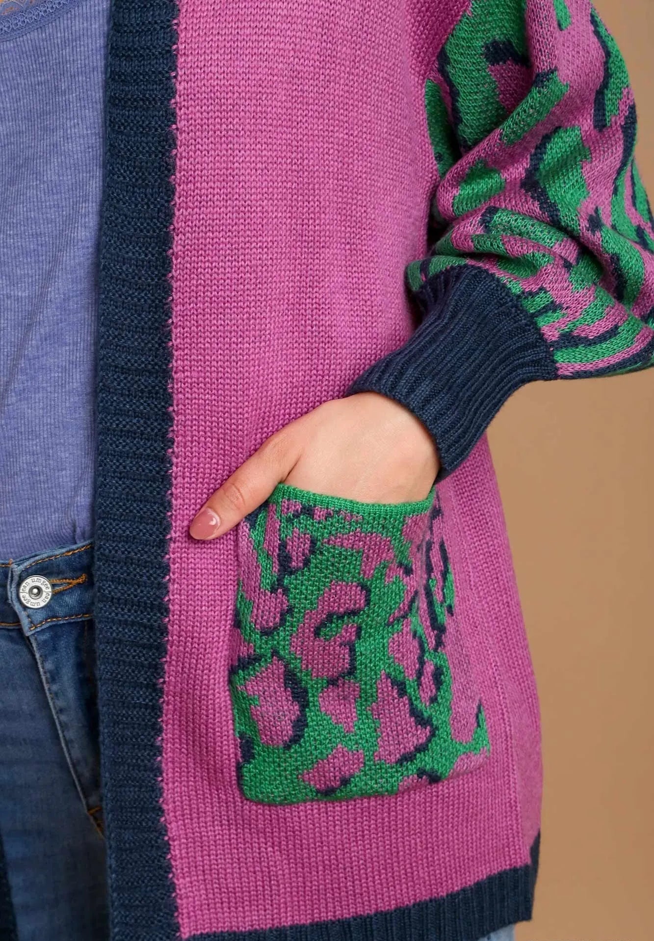Close-up of a pink and green patterned sweater with a pocket.