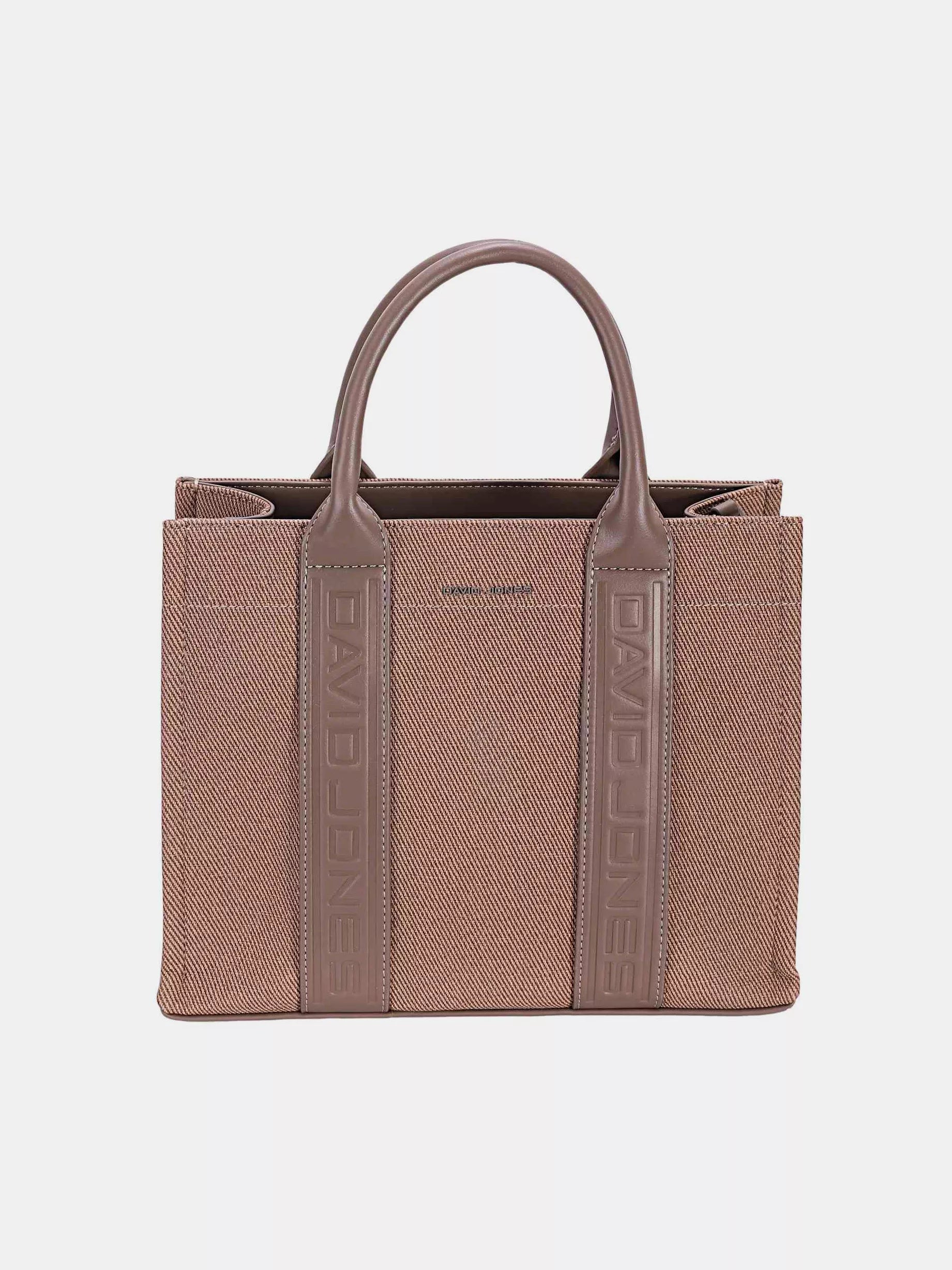 Brown tote bag with leather handles and visible branding on a white background